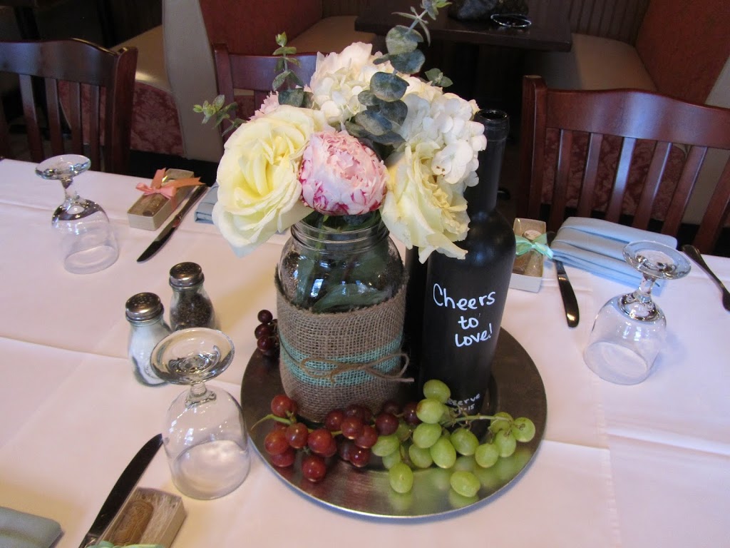 Handmade floral centerpieces for wine-inspired wedding using large mason jars, burlap and peonies
