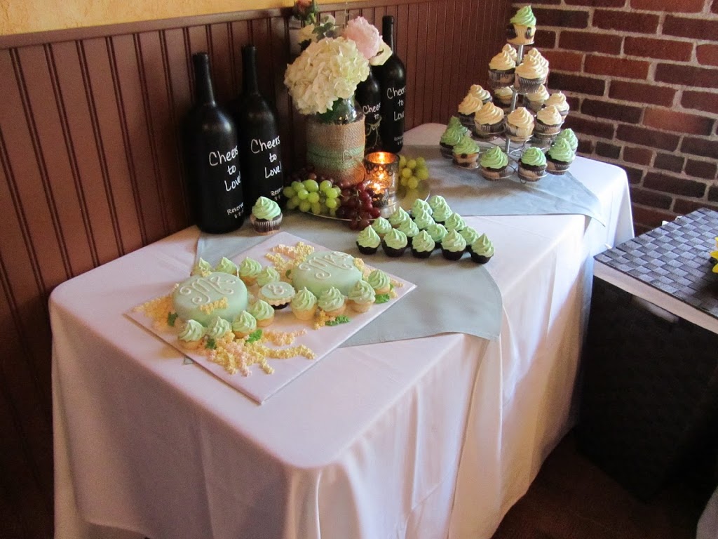 Wine-themed bridal shower dessert table with painted wine bottles and handmade floral centerpieces in mason jars